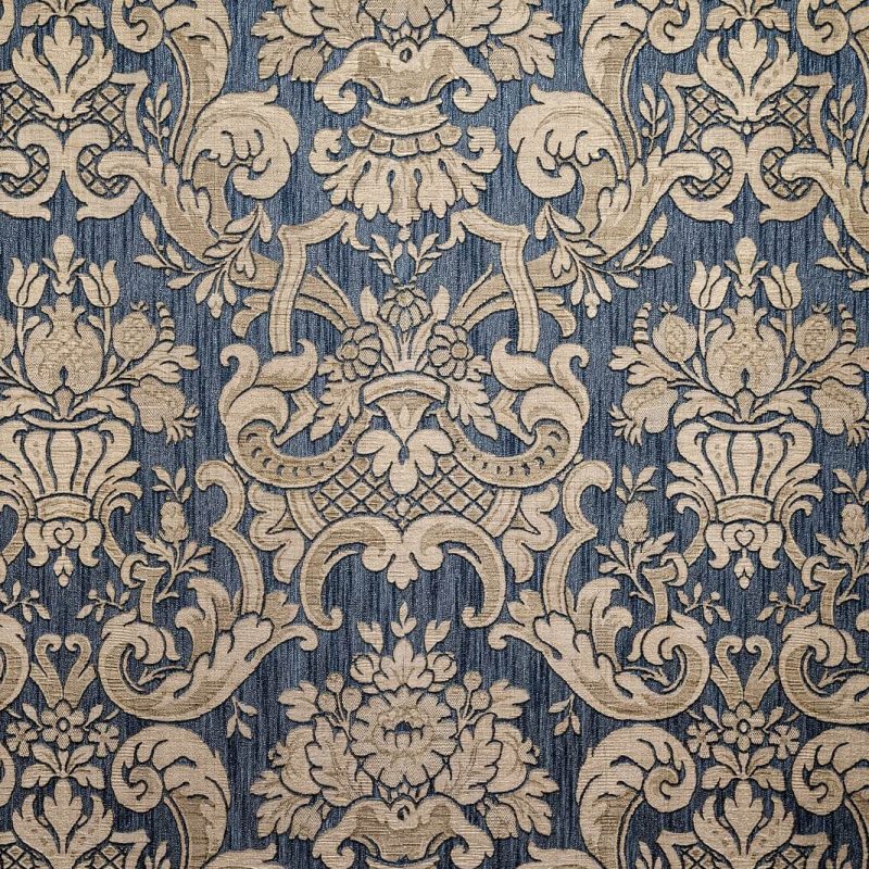 Motivo damascato blu e beige con ornamenti floreali eleganti.